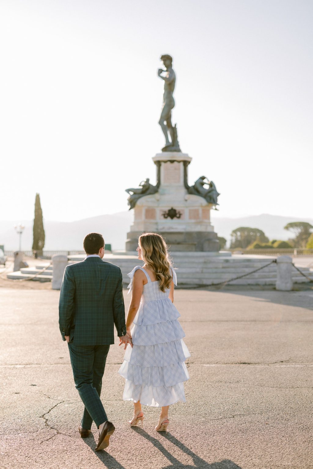 Engaged couple walking hand in hand in Florence during a sunrise engagement photoshoot.